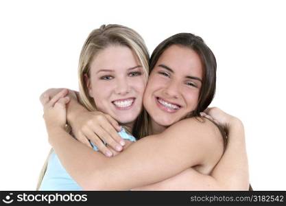 Two teen girls smiling and hugging over white background.