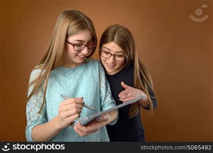 Two teen young friends using a computer tablet