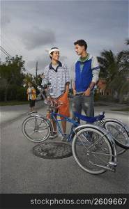 Two teenage boys standing behind a low rider bicycle