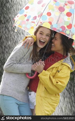 Two Teenage Girl Sheltering From Rain Beneath Umbrella