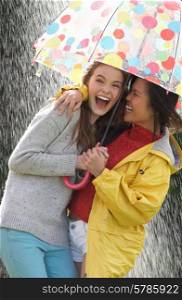 Two Teenage Girl Sheltering From Rain Beneath Umbrella