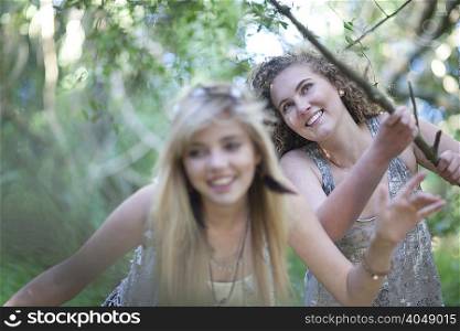 Two teenage girls discovering woodland