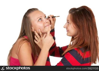 Two teenage girls dye their eyelashes isolated on a white background