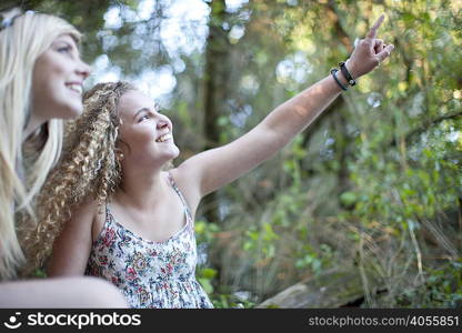 Two teenage girls exploring in woodland