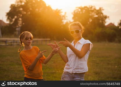 Two teenage girls have fun in the park. Two friends outdoor. Summer people in glasses