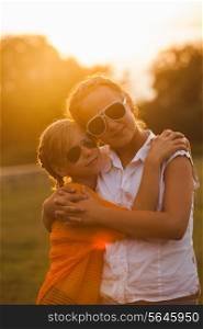 Two teenage girls have fun in the park. Two friends outdoor. Summer people in glasses