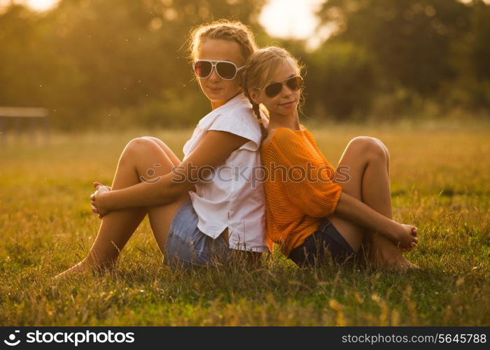 Two teenage girls have fun in the park. Two friends outdoor. Summwer people in glasses