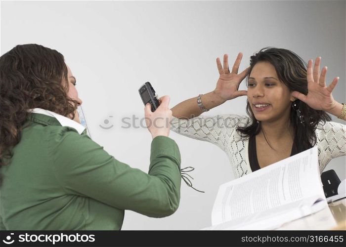 Two teenage girls having fun with a camera phone