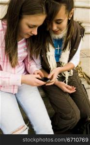 Two teenage girls holding a mobile phone