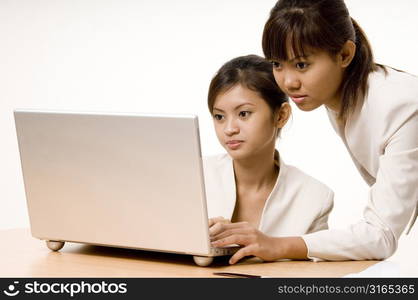 Two teenage girls looking at a laptop