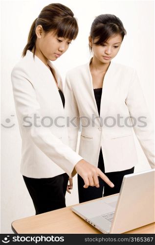 Two teenage girls looking at a laptop