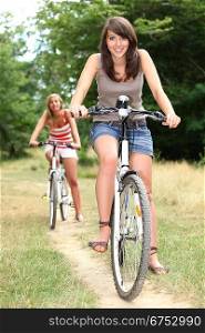 Two teenage girls on bikes
