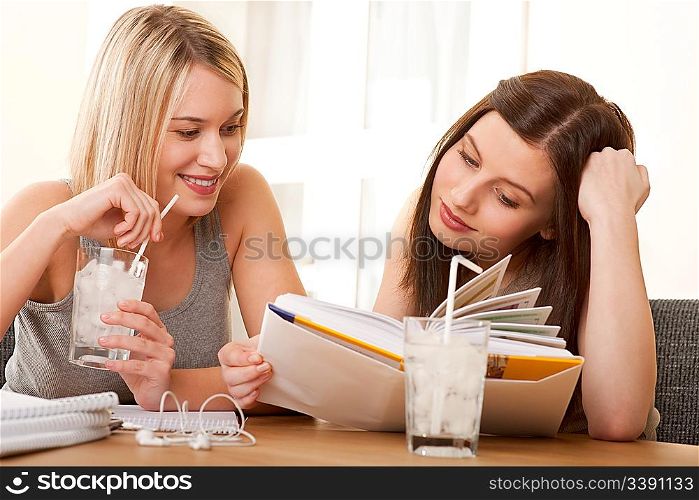 Two teenage girls reading together