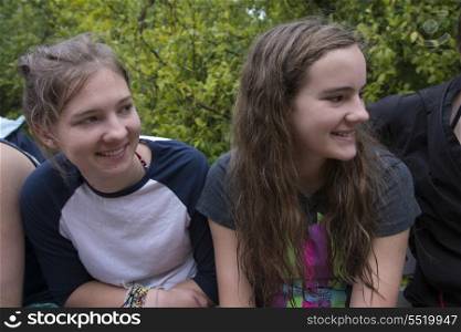 Two teenage girls sitting together and smiling, Utila, Bay Islands, Honduras