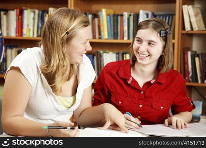 Two teenage girls studying together in the school library.