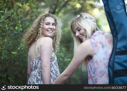 Two teenage girls walking in woodland
