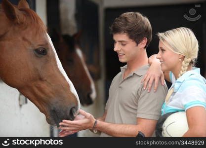 Two teenagers stood by horse stable