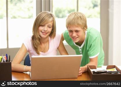 Two Teenagers Using Laptop At Home