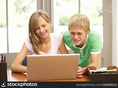 Two Teenagers Using Laptop At Home