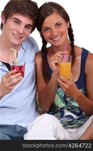 Two teenagers with fruit juice