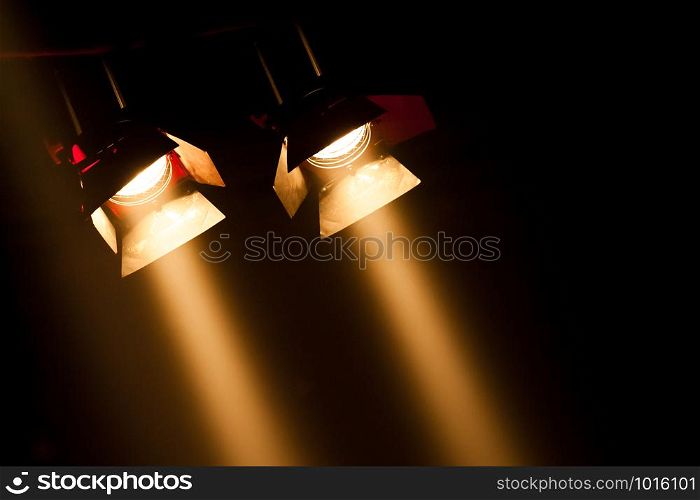 two theatre spotlights on a black background
