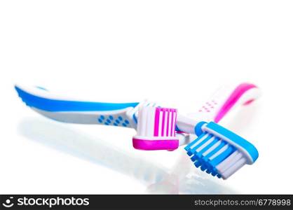 two toothbrushes crossed on a white background