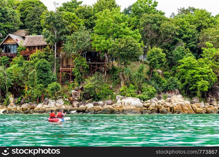 Two tourists are father and daughter travel by boat with a kayak in summer at front the resort on island of Ko Lipe enjoy the beautiful nature the sea in morning, Tarutao National Park, Satun, Thailand. Father and daughter travel by kayak at Ko Lipe, Thailand