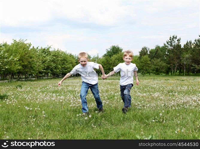 two twin brothers outdoors on the grass