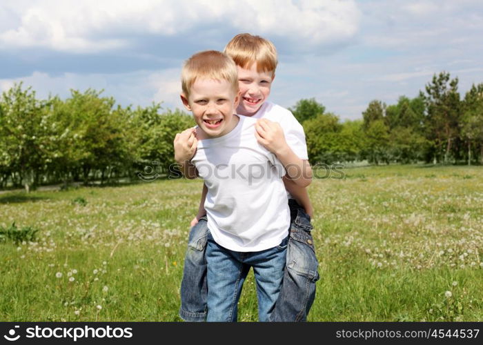 two twin brothers outdoors on the grass