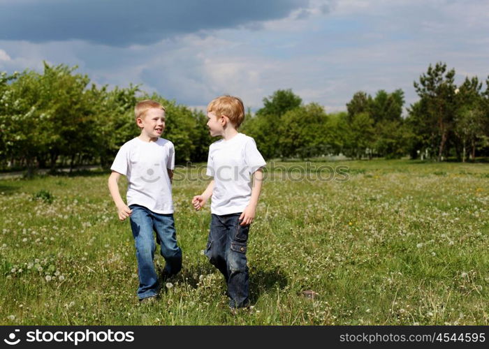 two twin brothers outdoors on the grass