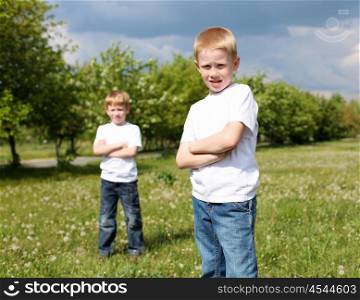 two twin brothers outdoors on the grass