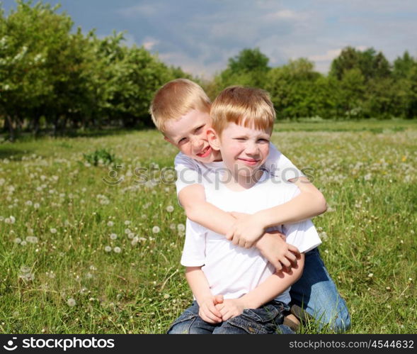 two twin brothers outdoors on the grass