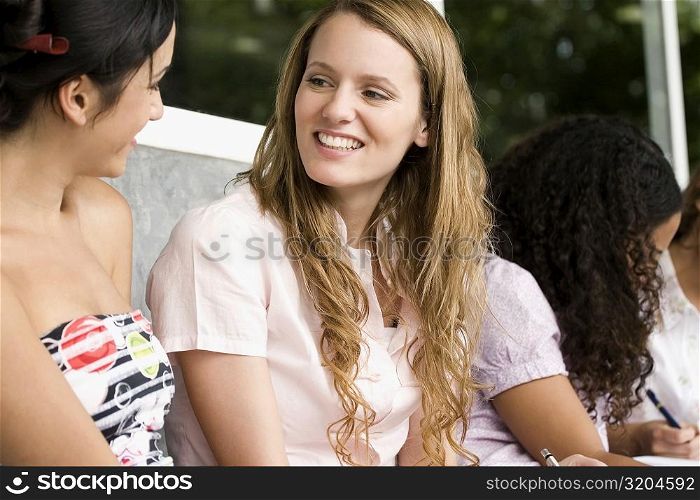 Two university students gossiping and smiling
