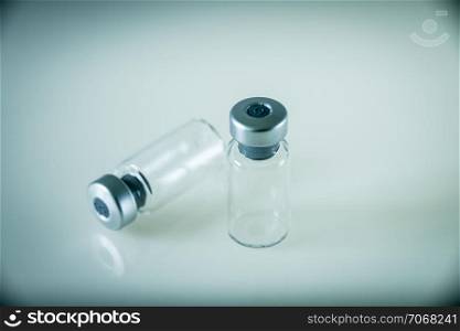 two vaccine glass bottles on grey background. two vaccine bottles on grey background