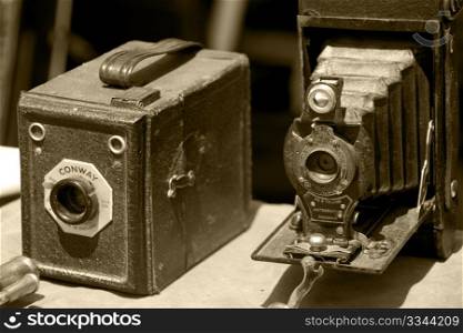 two very old photo cameras in sepia