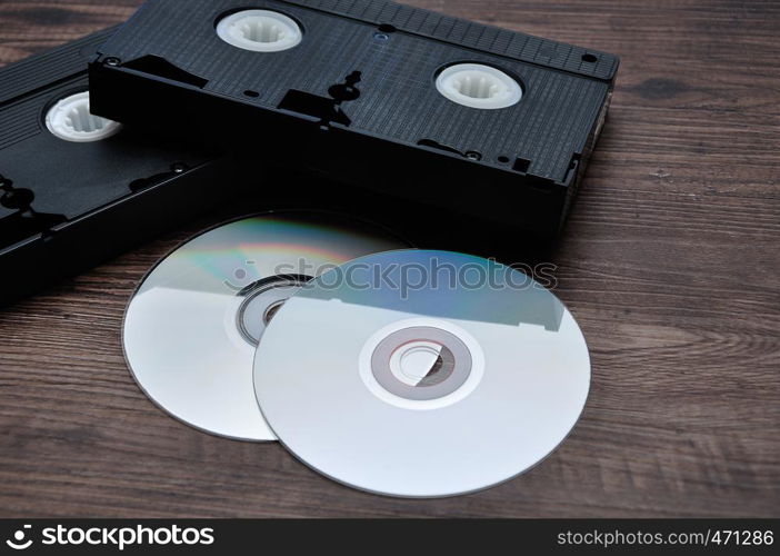 Two video cassettes isolated on a wooden background with cd's