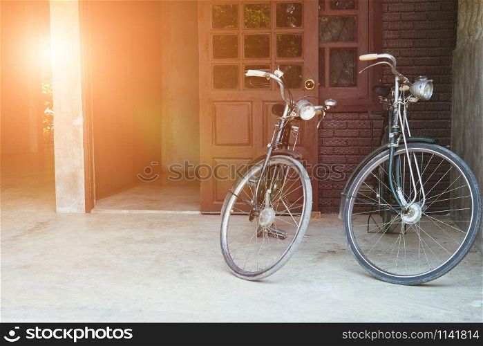 two vintage bicycle parked in front of brown door of house