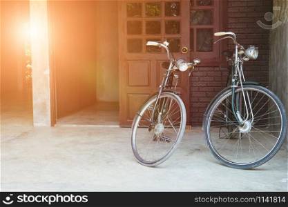 two vintage bicycle parked in front of brown door of house