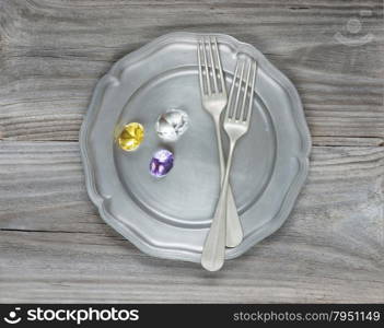 Two vintage fork and gems on an empty pink plate