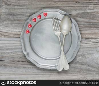 Two vintage fork and scarlet hearts on an empty plate
