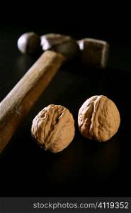 Two walnuts and old aged hammer