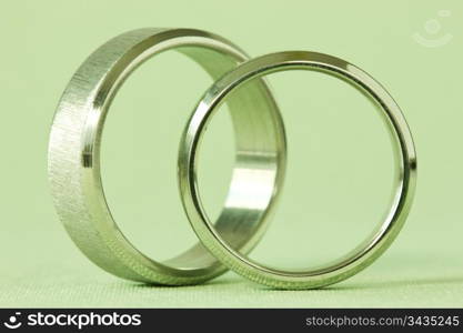 two wedding rings on a green background