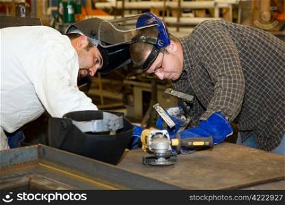 Two welders working together on a difficult metal work project. Authentic and accurate content depiction in compliance with industry code and safety standards.