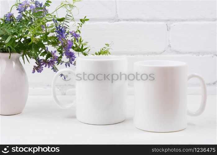 Two white coffee mug mockup with purple mouse peas flowers. Empty mug mock up for design promotion.