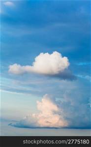 two white cumulus clouds in blue afrernoon sky