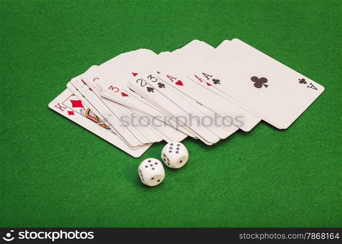 Two White Dices And Playing Cards On Green Cloth