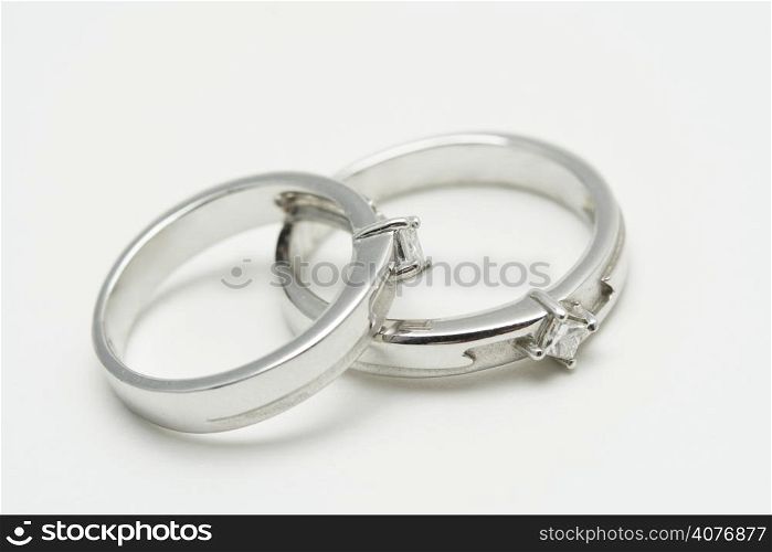 Two white gold wedding rings on silver background