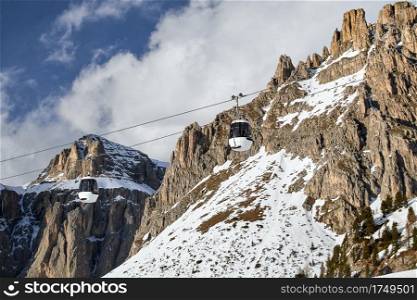 two white ski lift cabins in front of the typical rugged, rugged majestic rocks in the Italian Dolomites at the sellaronda ski area. two ski lift cabins in front of the typical rugged, rugged majestic rocks in the Italian Dolomites