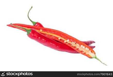 Two whole and one half red chili peppers deployed isolated on white background