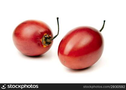 Two whole ripe and juicy tamarillo on white background